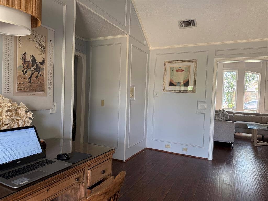 1517 Aylesbury Lane, Plano, TX 75075 Wood-finish flooring, paneled wall detailing, vaulted ceiling, and an arched entryway