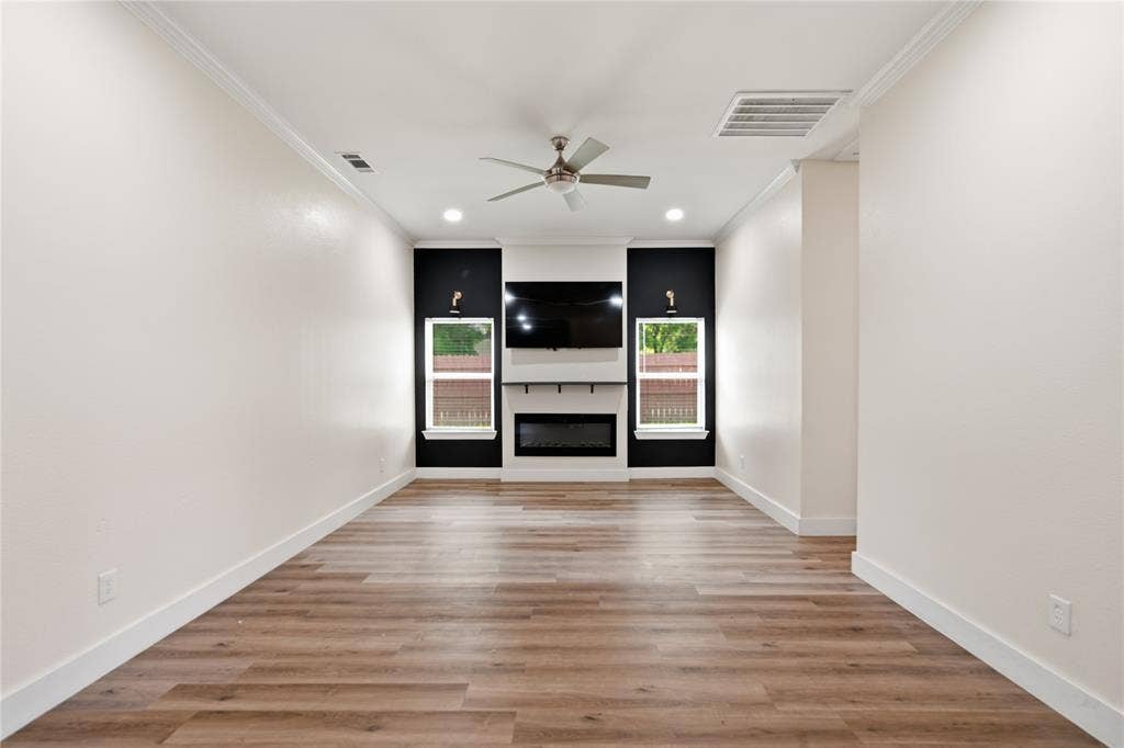 Spacious living area featuring wood-finish flooring, recessed lighting, and a ceiling fan