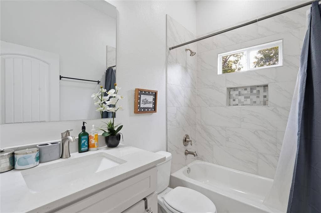 Bathroom featuring a single vanity with an integrated sink and brushed nickel faucet