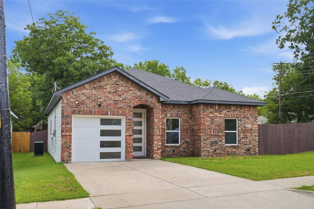 Brick facade home featuring a single-car garage with frosted panel inserts and a covered entry
