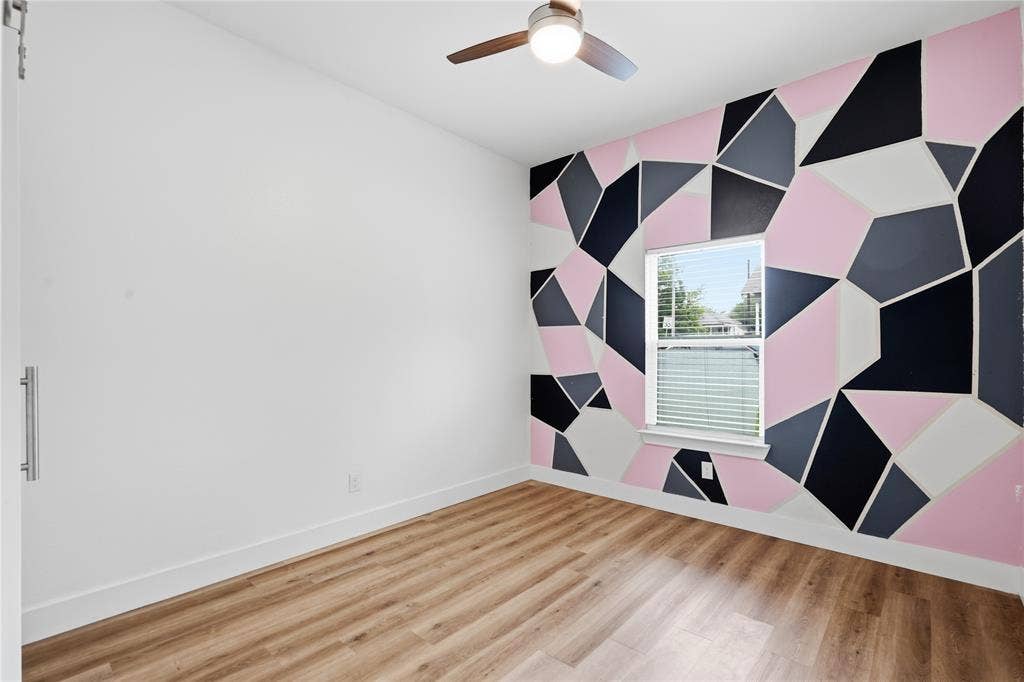 Room featuring a geometric accent wall in pink, black, gray, and white