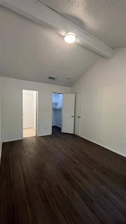 Bedroom 1 -Vaulted ceiling with exposed beam, wood-finish flooring, and a single window