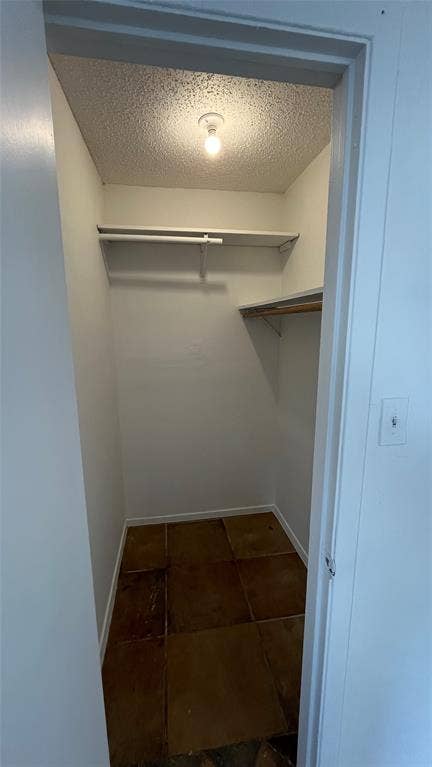 Bedroom 3 -  Walk-In Closet Integrated overhead lighting, built-in shelving, and tile flooring
