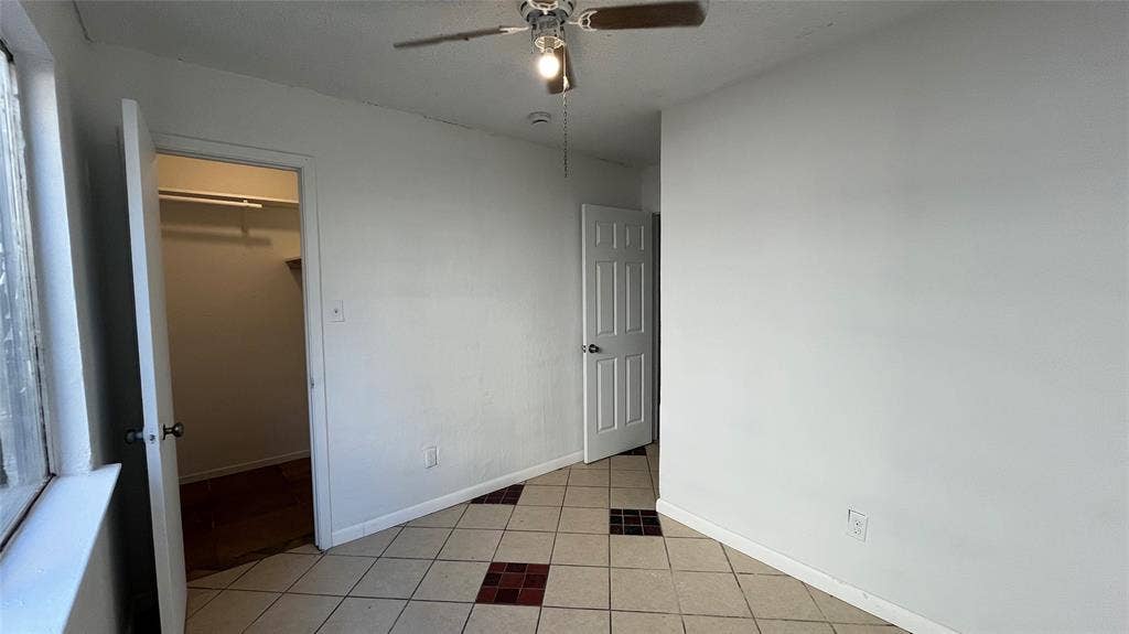 Bedroom 3 - Tile flooring with accent inserts, ceiling fan with integrated lighting, window with white trim, and a white interior door