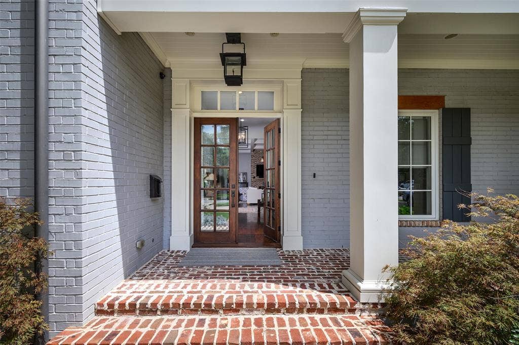 3420 Hanover Street, University Park, TX 75225 Painted brick exterior with a columned front porch, brick steps, and wood-finish French doors