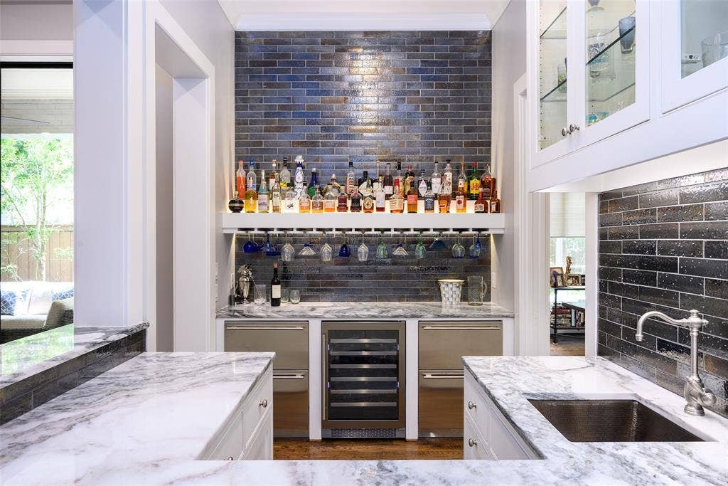 3420 Hanover Street, University Park, TX 75225 Wet bar with integrated wine refrigerator, under-cabinet lighting, glass-front cabinetry, and a subway tile backsplash