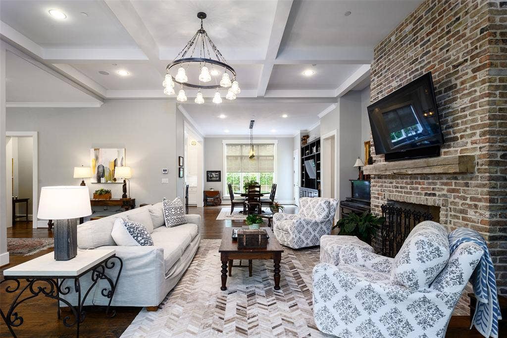 3420 Hanover Street, University Park, TX 75225 Coffered ceiling, overhead chandelier, brick fireplace with stone mantel, recessed lighting, and dark wood flooring