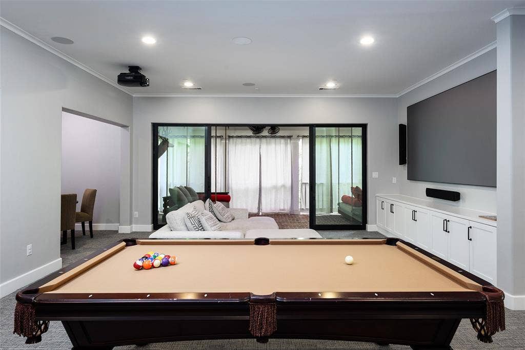 3420 Hanover Street, University Park, TX 75225 Recessed lighting, built-in cabinetry with dark hardware, large wall-mounted screen, and sliding glass doors