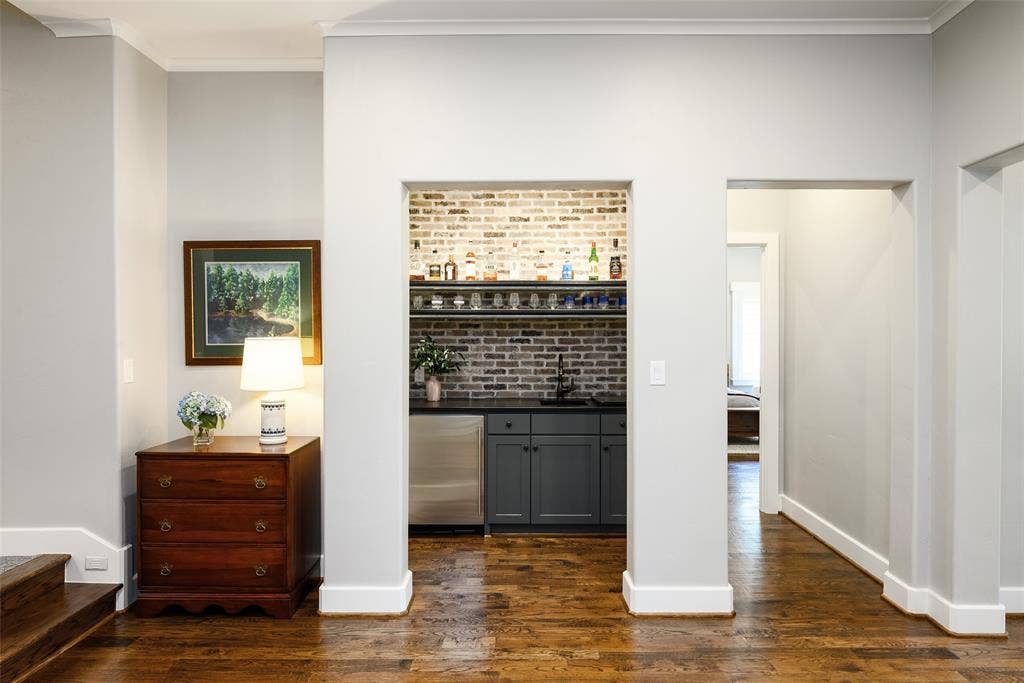 3420 Hanover Street, University Park, TX 75225 Built-in wet bar featuring a brick accent wall, stainless steel beverage refrigerator, dark cabinetry, and a dark countertop