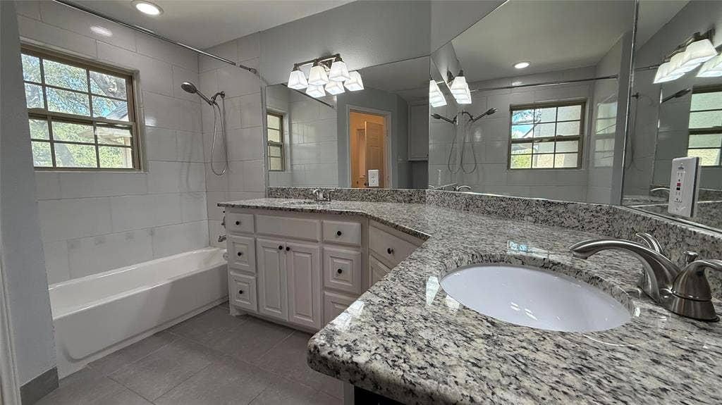 Double vanity with stone-finish countertops, undermount sinks, and brushed nickel fixtures