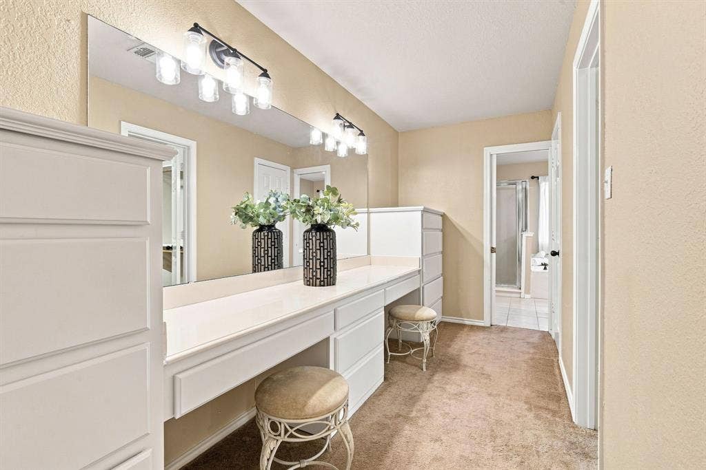Dedicated vanity and get-ready space with a long countertop, statement mirror with vanity lighting, and built-in storage, the perfect spot to start your day.