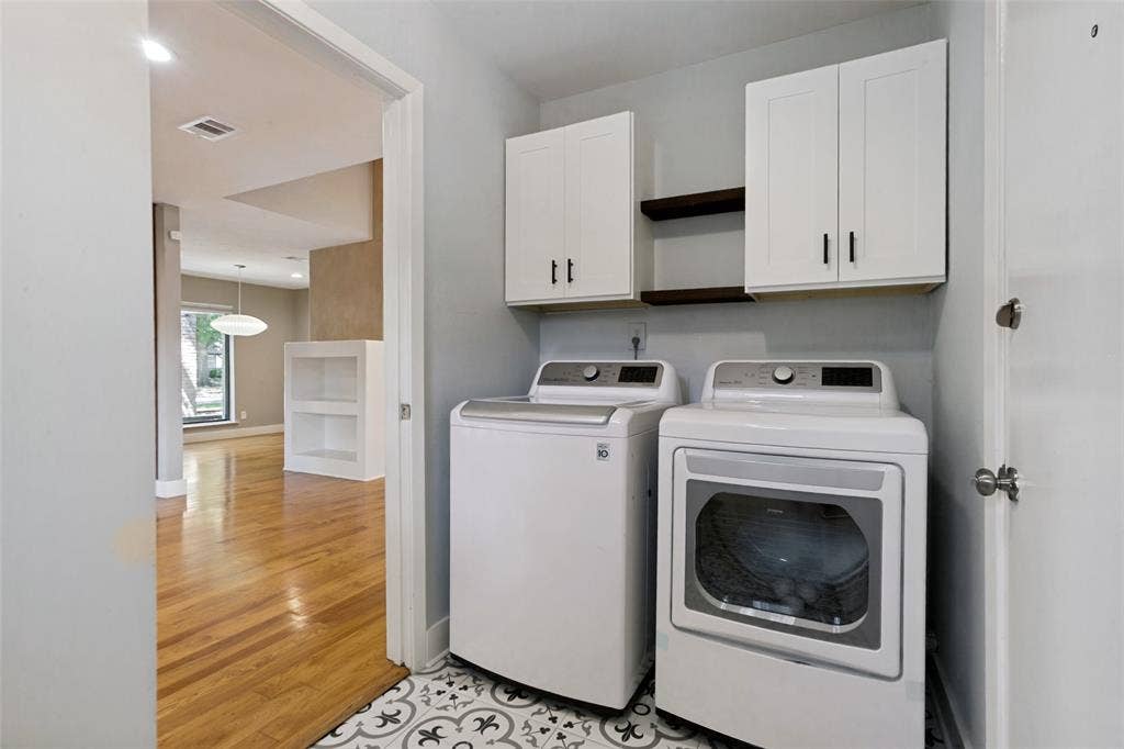 2937 Forest Hills Lane, Richardson, TX 75080 Laundry area with patterned floor tile, white shaker-style cabinetry, and wood-finish shelving