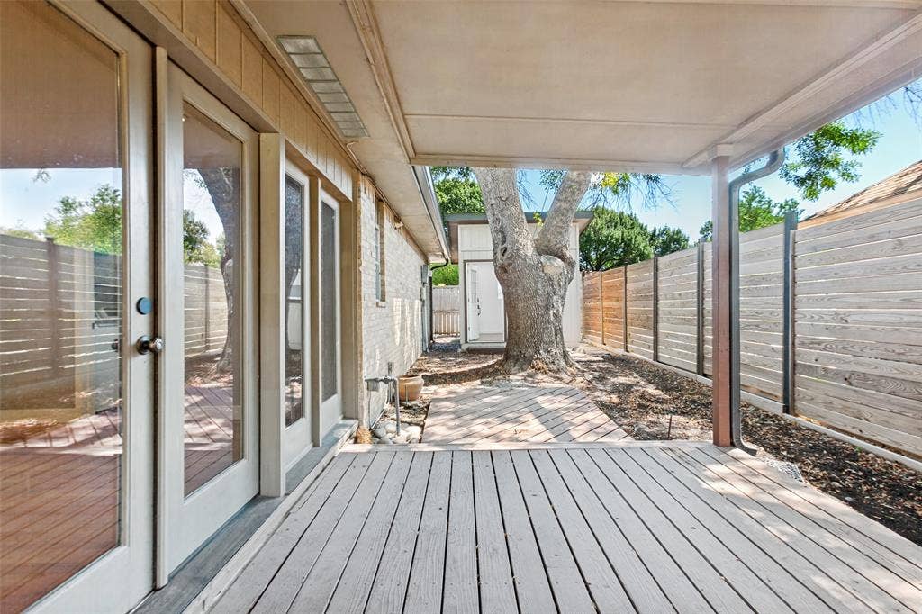 2937 Forest Hills Lane, Richardson, TX 75080 Covered wood deck with multiple glass-paned doors and a wood fence