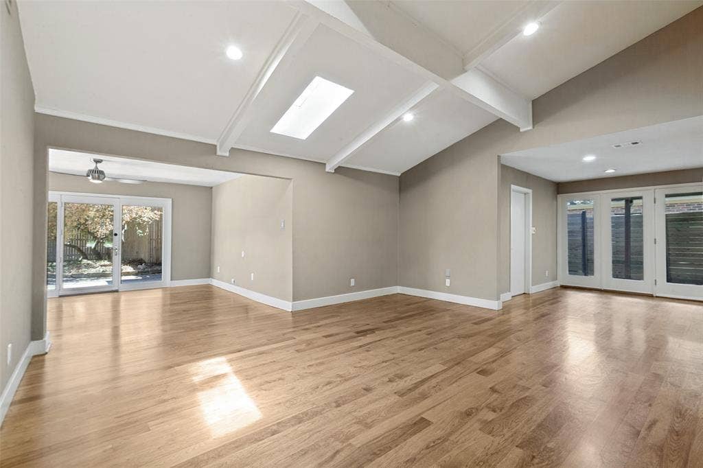 2937 Forest Hills Lane, Richardson, TX 75080 Vaulted ceiling with exposed beams, skylight, recessed lighting, wood-finish flooring, and sliding glass doors