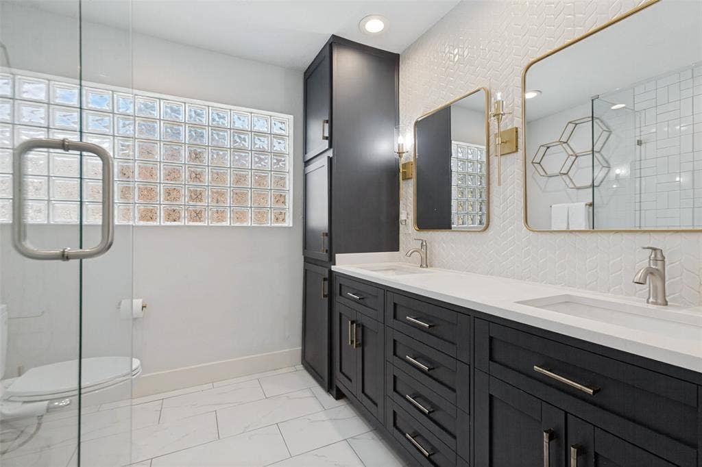 2937 Forest Hills Lane, Richardson, TX 75080 Dual vanity with integrated sinks, dark wood-finish cabinetry, and white countertops