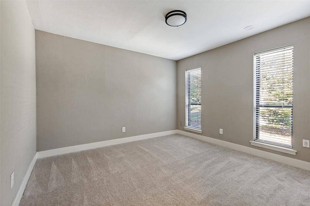 2937 Forest Hills Lane, Richardson, TX 75080 Neutral-toned walls, carpet flooring, two vertical windows with blinds, and a flush-mount ceiling light