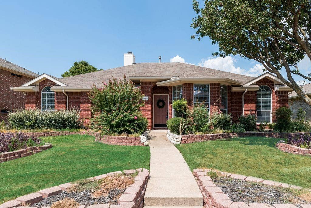 1485 Ashbourne Drive, Rockwall, TX 75087 Welcoming brick exterior with arched entryways, mature landscaping, and manicured lawn