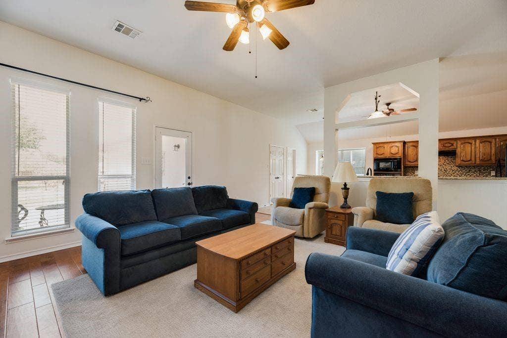 1485 Ashbourne Drive, Rockwall, TX 75087 Hardwood-style flooring, white walls, arched entryway, ceiling fan with integrated lighting, and multiple windows