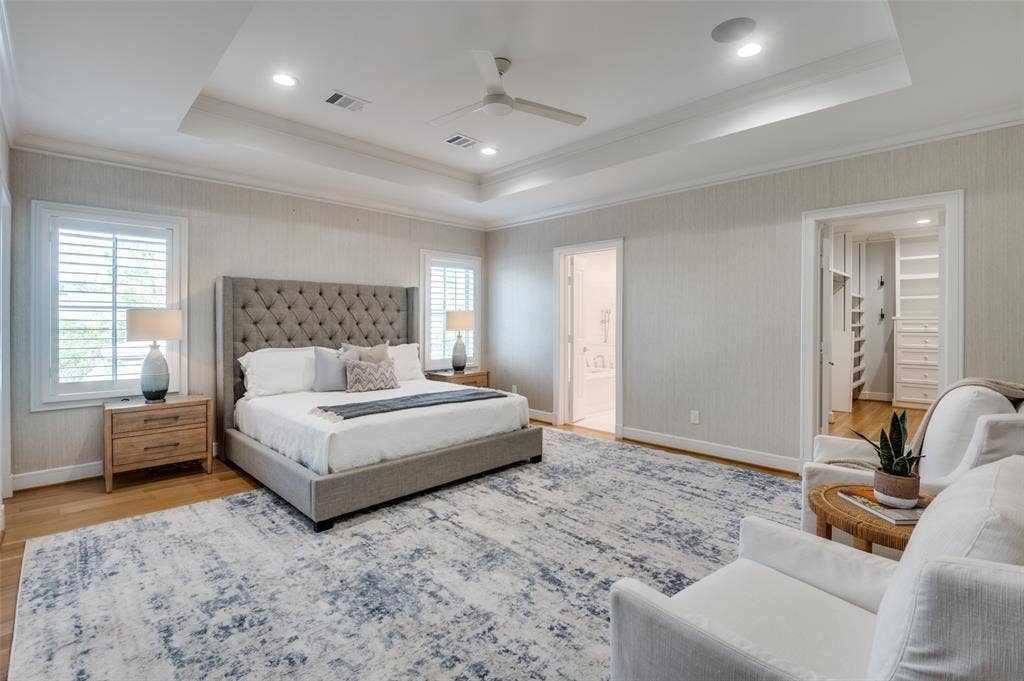 4031 Prescott Avenue, Dallas, TX 75219 Tray ceiling with recessed lighting and ceiling fan, wood-finish flooring, two large windows with plantation shutters, and a built-in closet system
