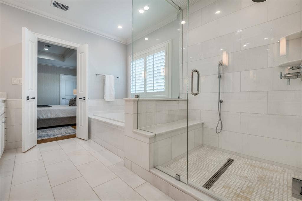 4031 Prescott Avenue, Dallas, TX 75219 Spacious bathroom featuring a glass-enclosed shower with bench, built-in tub, and tile flooring