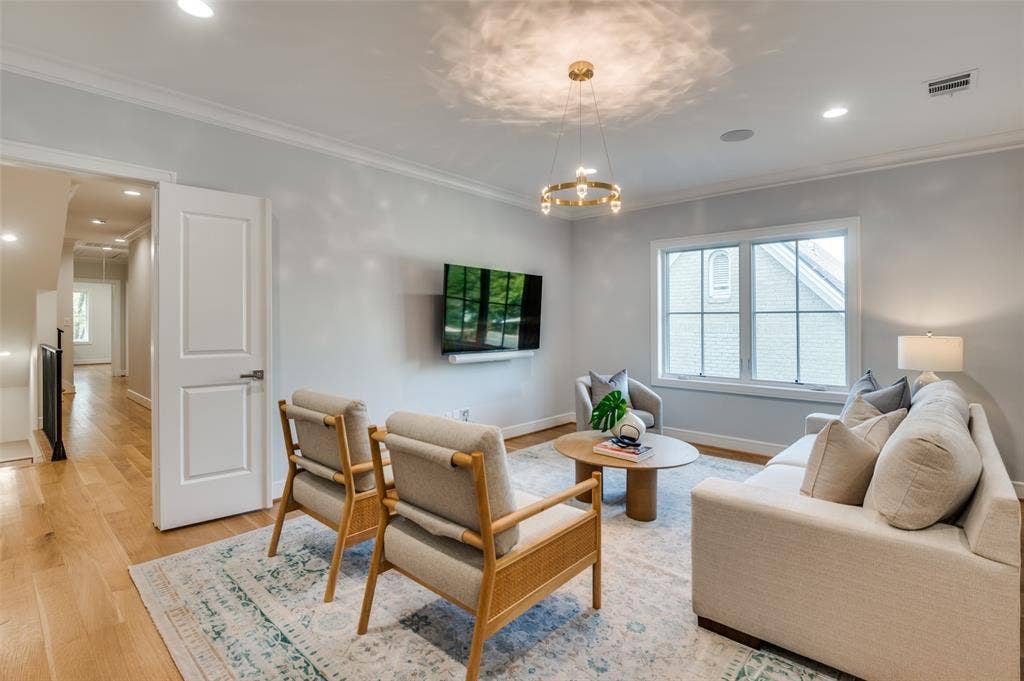 4031 Prescott Avenue, Dallas, TX 75219 Hardwood flooring, recessed lighting, crown molding, modern chandelier, and a bright window with grilles