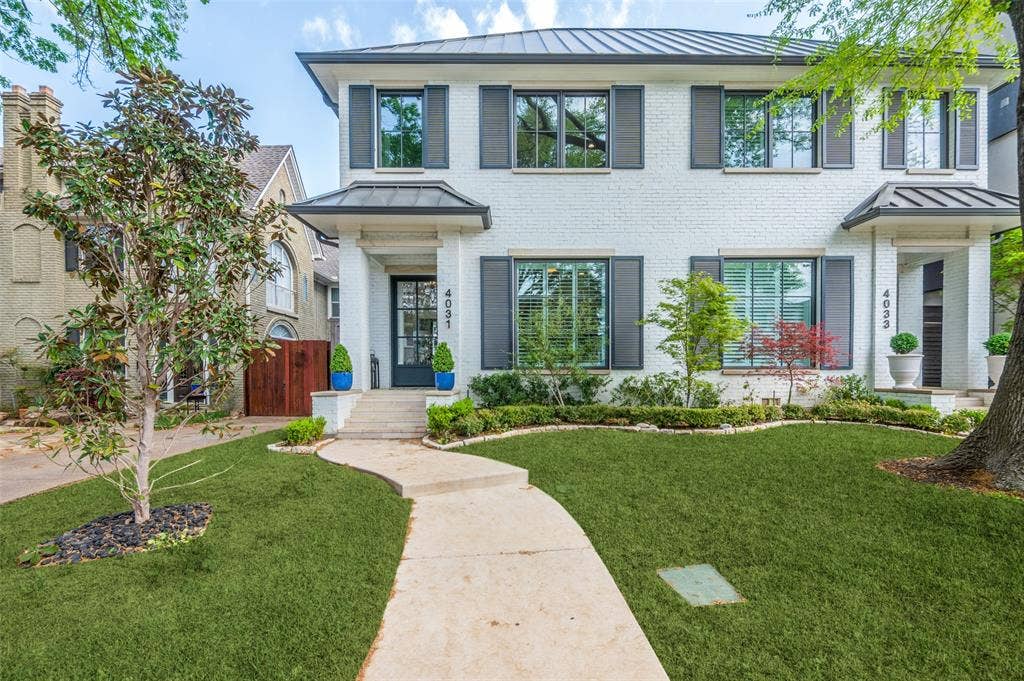4031 Prescott Avenue, Dallas, TX 75219 White brick exterior with dark shutters, gabled metal roof, and a concrete pathway