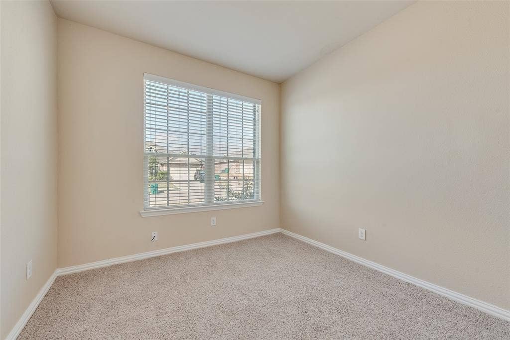 215 Fred Lane, Ferris, TX 75125 Neutral-toned walls complement the light-colored carpet flooring