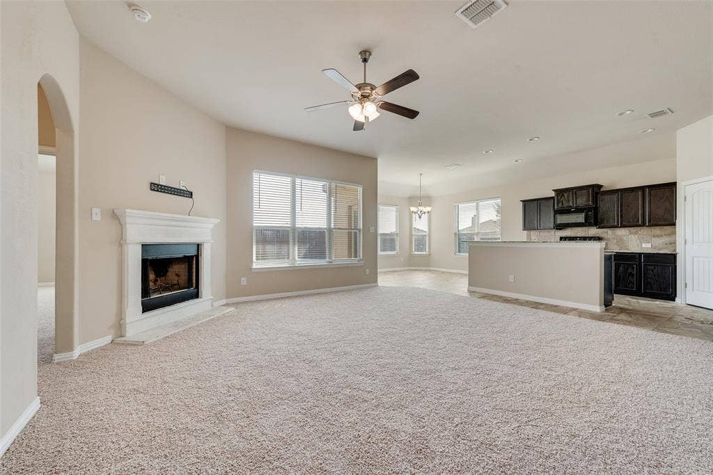 215 Fred Lane, Ferris, TX 75125 Expansive living area with vaulted ceilings, a fireplace, and large windows