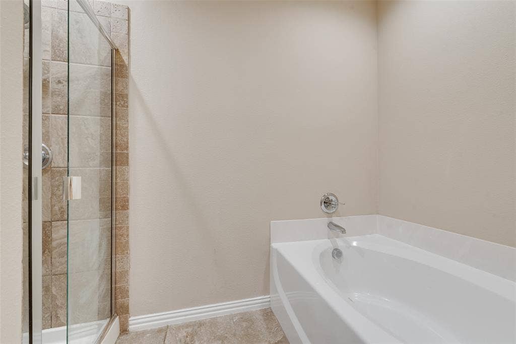 215 Fred Lane, Ferris, TX 75125 Bathtub with chrome fixtures, tiled shower surround, and glass shower enclosure