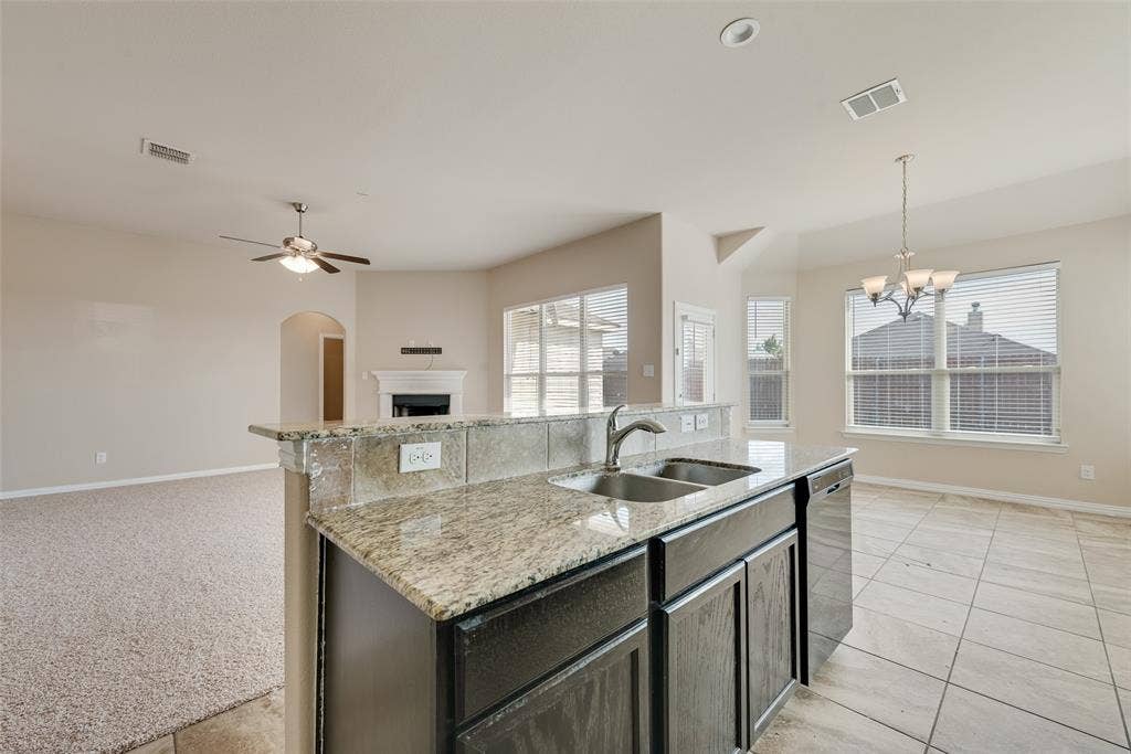 215 Fred Lane, Ferris, TX 75125 Kitchen island with granite countertops, double basin sink, and integrated dishwasher