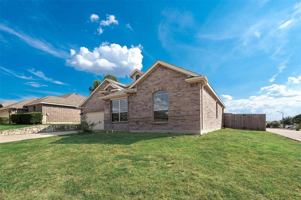 215 Fred Lane, Ferris, TX 75125 Brick exterior with an attached garage, arched window, and gabled roofline