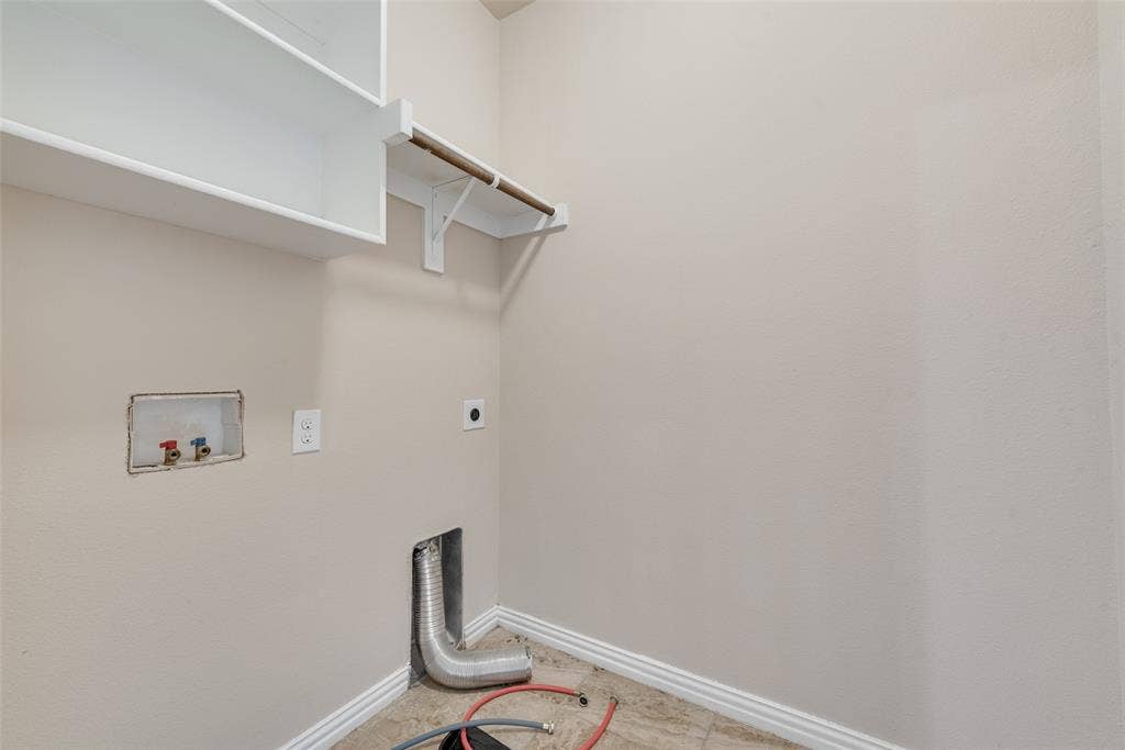 215 Fred Lane, Ferris, TX 75125 Utility area with upper shelving, clothes hanging rod, and appliance hookups