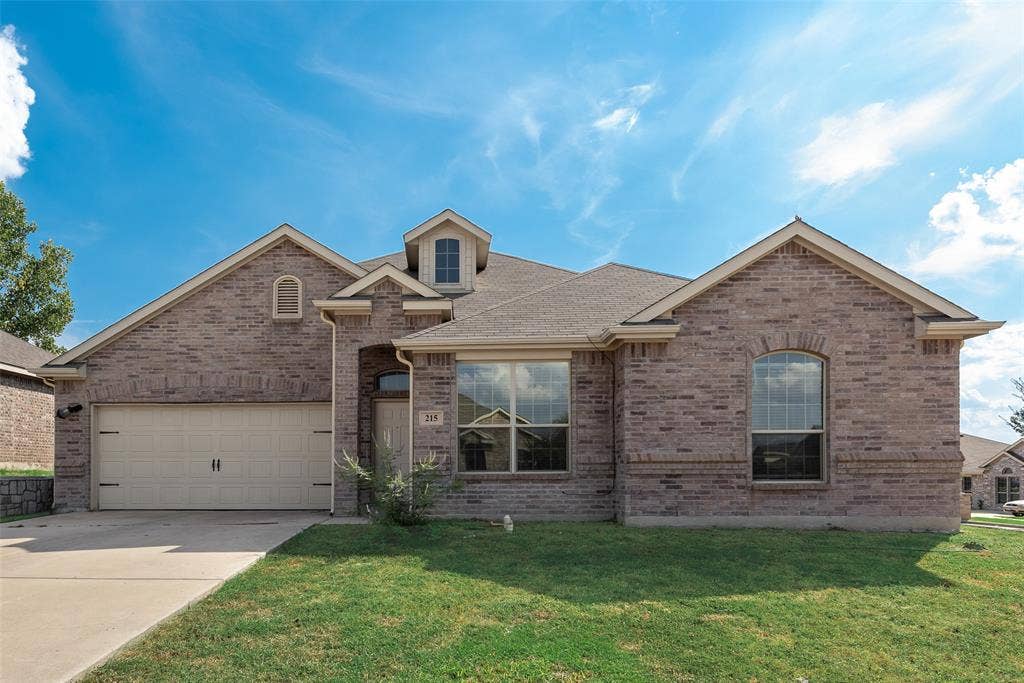 215 Fred Lane, Ferris, TX 75125 Brick exterior with multiple gables, arched windows, an integrated garage, and a dormer window