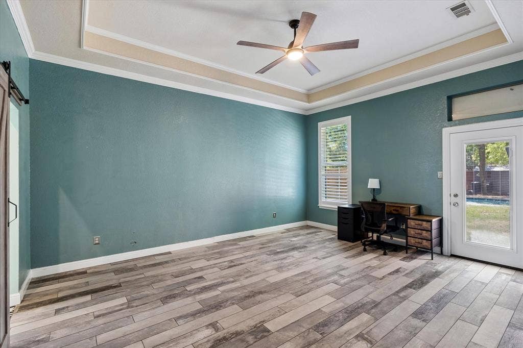 3800 Deer Forest Drive, Denton, TX 76208 Tray ceiling with crown molding, wood-finish flooring, ceiling fan, natural light from exterior window, and glass-paneled exterior door
