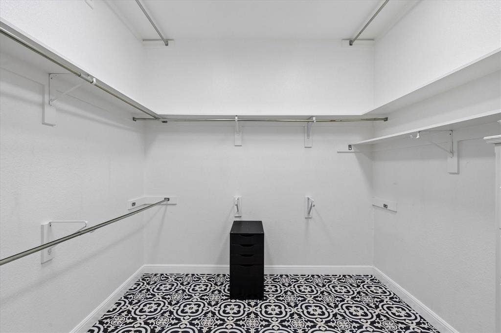 3800 Deer Forest Drive, Denton, TX 76208 Spacious closet featuring patterned floor tiles, multiple clothing rods, and extensive shelving