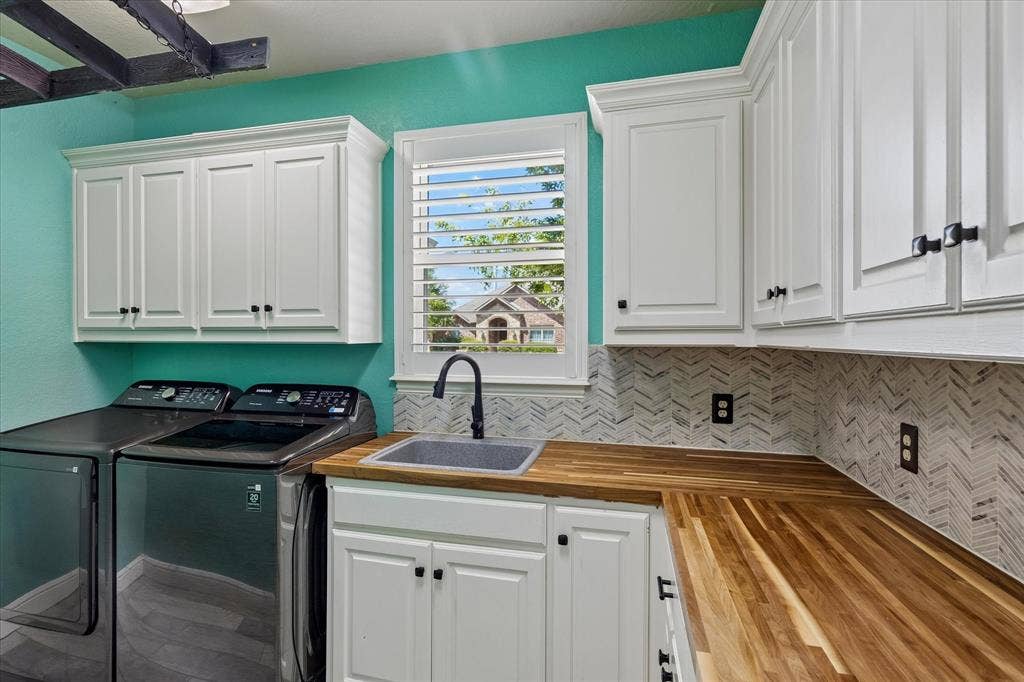 3800 Deer Forest Drive, Denton, TX 76208 White shaker-style cabinetry, wood-finish countertops, undermount sink with a matte black faucet, and chevron-patterned tile backsplash