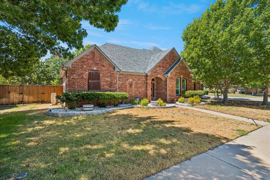 3800 Deer Forest Drive, Denton, TX 76208 Brick exterior with a gray shingle roof and arched entryway