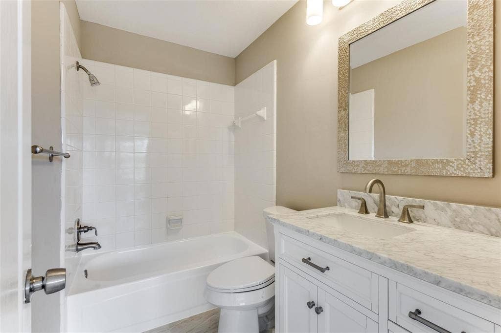 2822 Roundrock, McKinney, TX 75072 2nd full bath updstairs with stone countertop, bronze-finish faucet, and an ornate framed mirror
