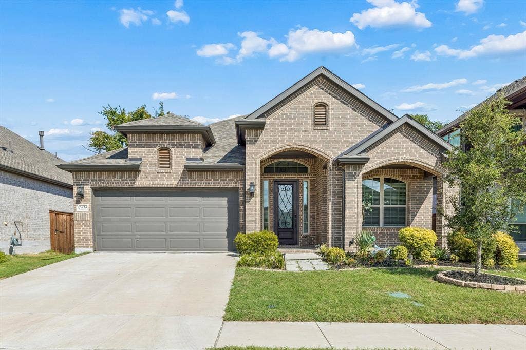 5224 Troupe Road, McKinney, TX 75071 Brick facade with arched entryways, an attached two-car garage, mature landscaping, and an ornate front door