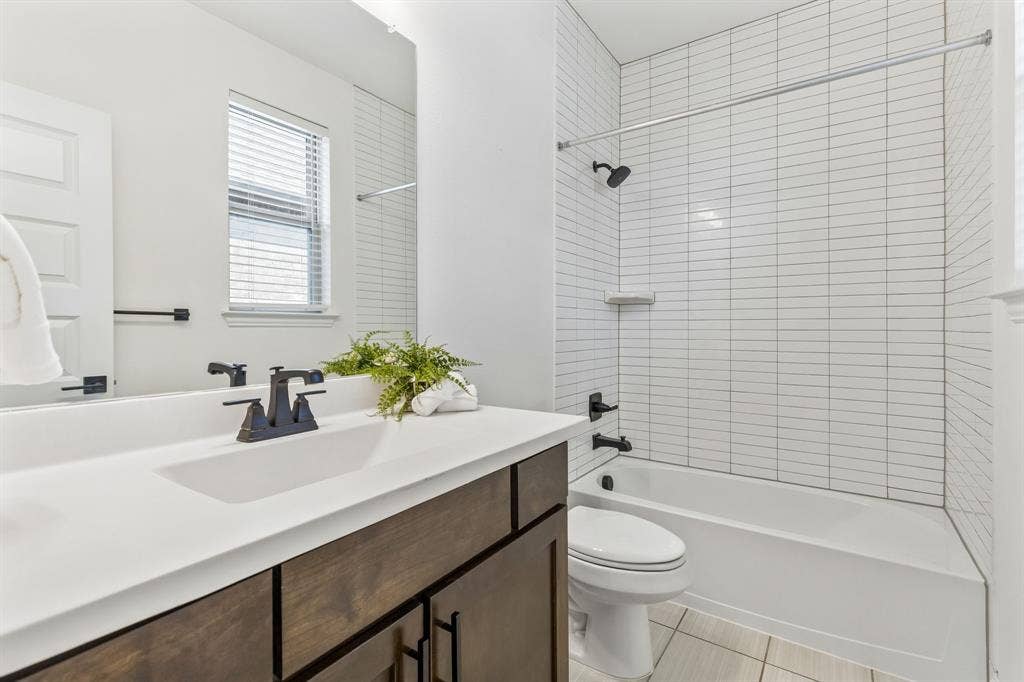 5224 Troupe Road, McKinney, TX 75071 Bathroom featuring a single vanity with dark wood-finish cabinetry, solid surface countertop, and matte black fixtures