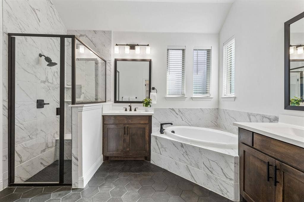 5224 Troupe Road, McKinney, TX 75071 Hexagonal tile flooring, walk-in shower with black-framed glass enclosure, built-in soaking tub, dual wood-finish vanity with countertop, and double-paned windows