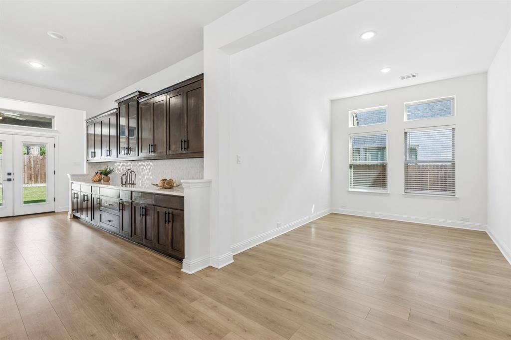 5224 Troupe Road, McKinney, TX 75071 Wood-finish flooring throughout, with a built-in cabinetry unit featuring a white countertop and tile backsplash