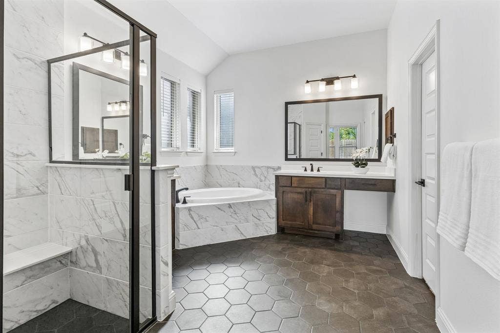5224 Troupe Road, McKinney, TX 75071 Tiled walk-in shower with a built-in bench and dark-framed glass enclosure