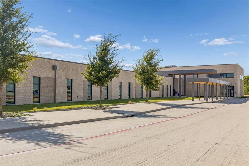 5224 Troupe Road, McKinney, TX 75071 Modern brick exterior with expansive windows, an extended porte-cochere, and mature landscaping