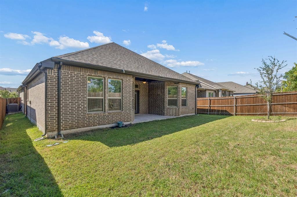 5224 Troupe Road, McKinney, TX 75071 Brick exterior home featuring a covered patio, fenced yard, and a young tree