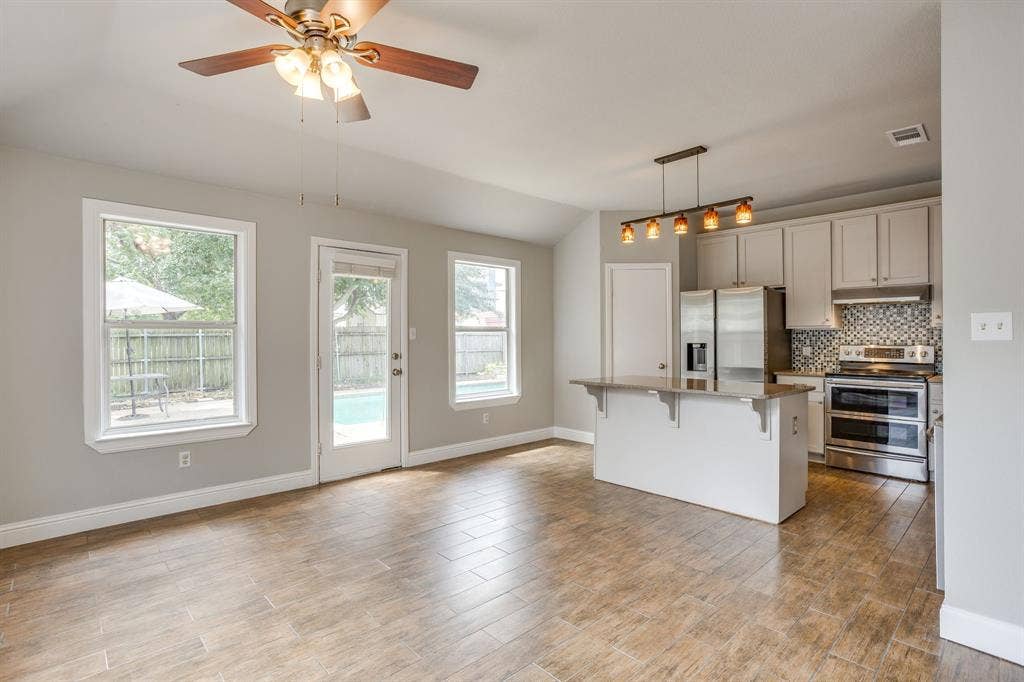 9825 Stoney Bridge Road, Fort Worth, TX 76108 Remodeled kitchen with island, granite counters, & decorative lighting.
