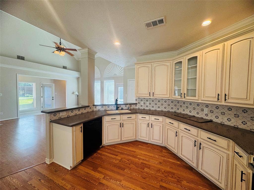 Kitchen with light-toned cabinetry, dark countertops, and a patterned backsplash