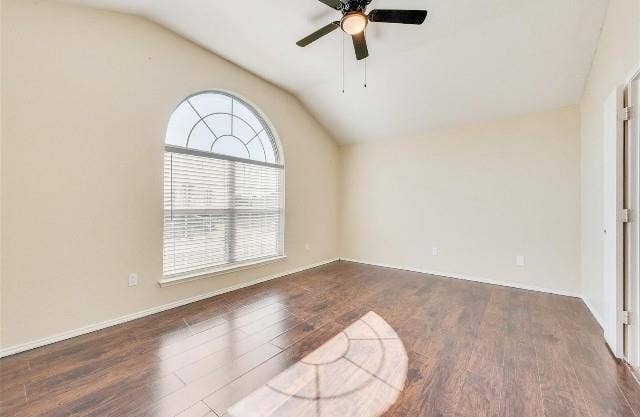 1405 Teal Way, Midlothian, TX 76065 Vaulted ceiling with a ceiling fan, arched window with horizontal blinds, wood-finish flooring, and light-toned walls