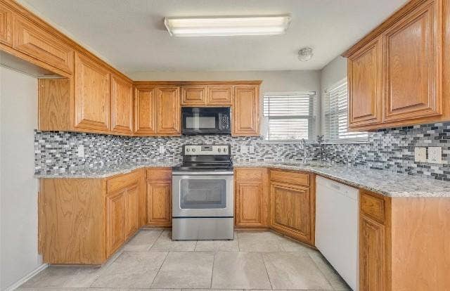 1405 Teal Way, Midlothian, TX 76065 U-shaped kitchen with wood cabinetry, tile flooring, a mosaic tile backsplash, and light-toned countertops