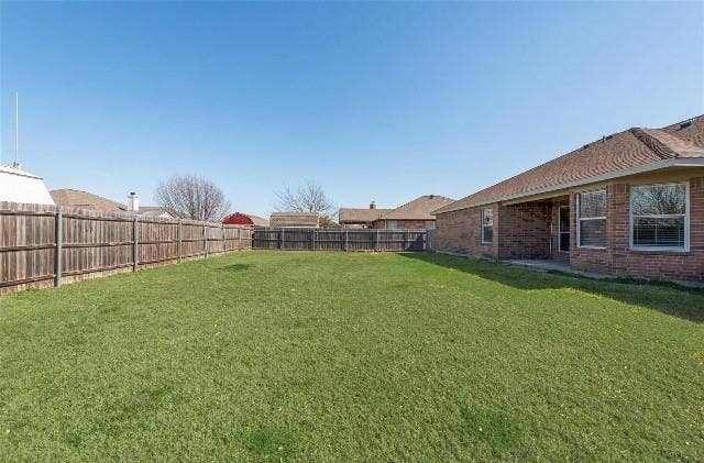 1405 Teal Way, Midlothian, TX 76065 Expansive backyard featuring a manicured lawn, full wood privacy fencing, a covered patio, and a brick exterior